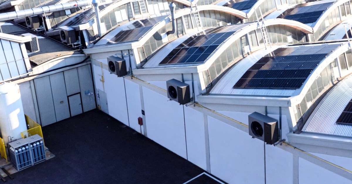 Kita Air udendørsenheder på taget af en industrihal med solceller