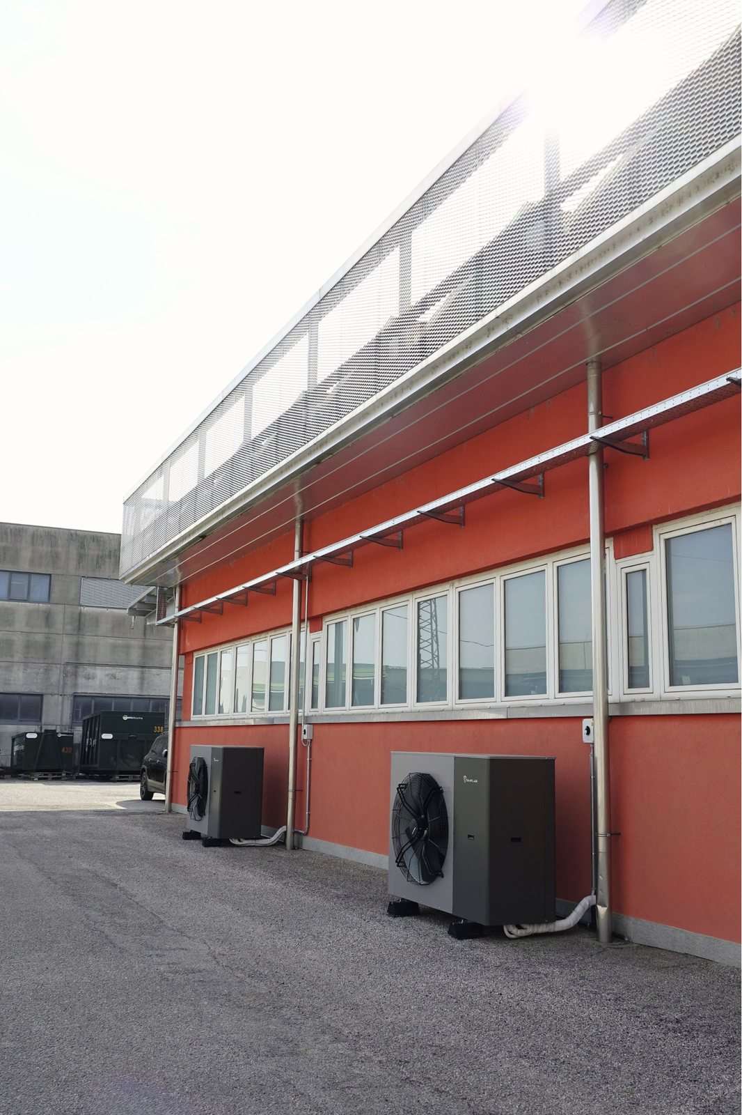 Zwei Kita Air Außengeräte am Boden entlang der Fassade einer Halle
